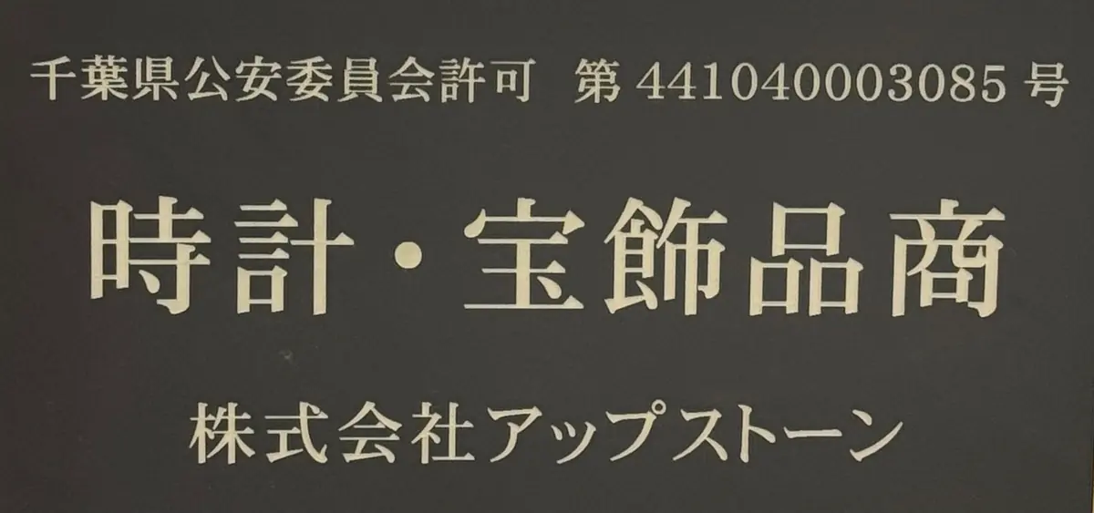 古物商の許可番号と「時計・宝飾品商」を刻んだ黒い金属プレート